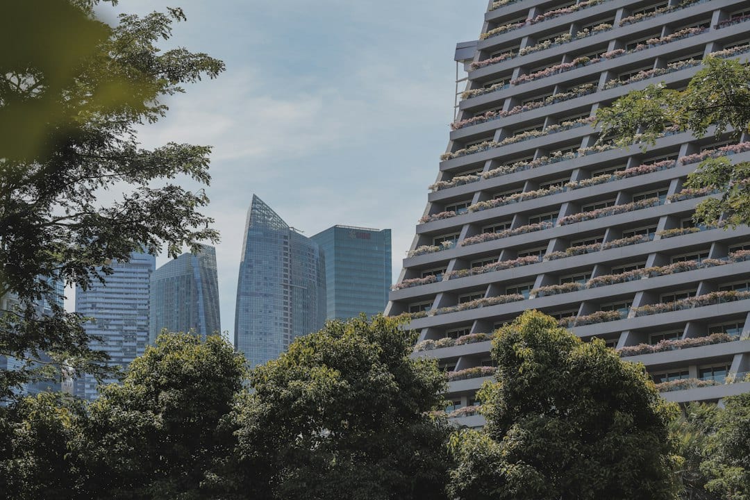 Exterior view of a tall modern condominium with planted balconies